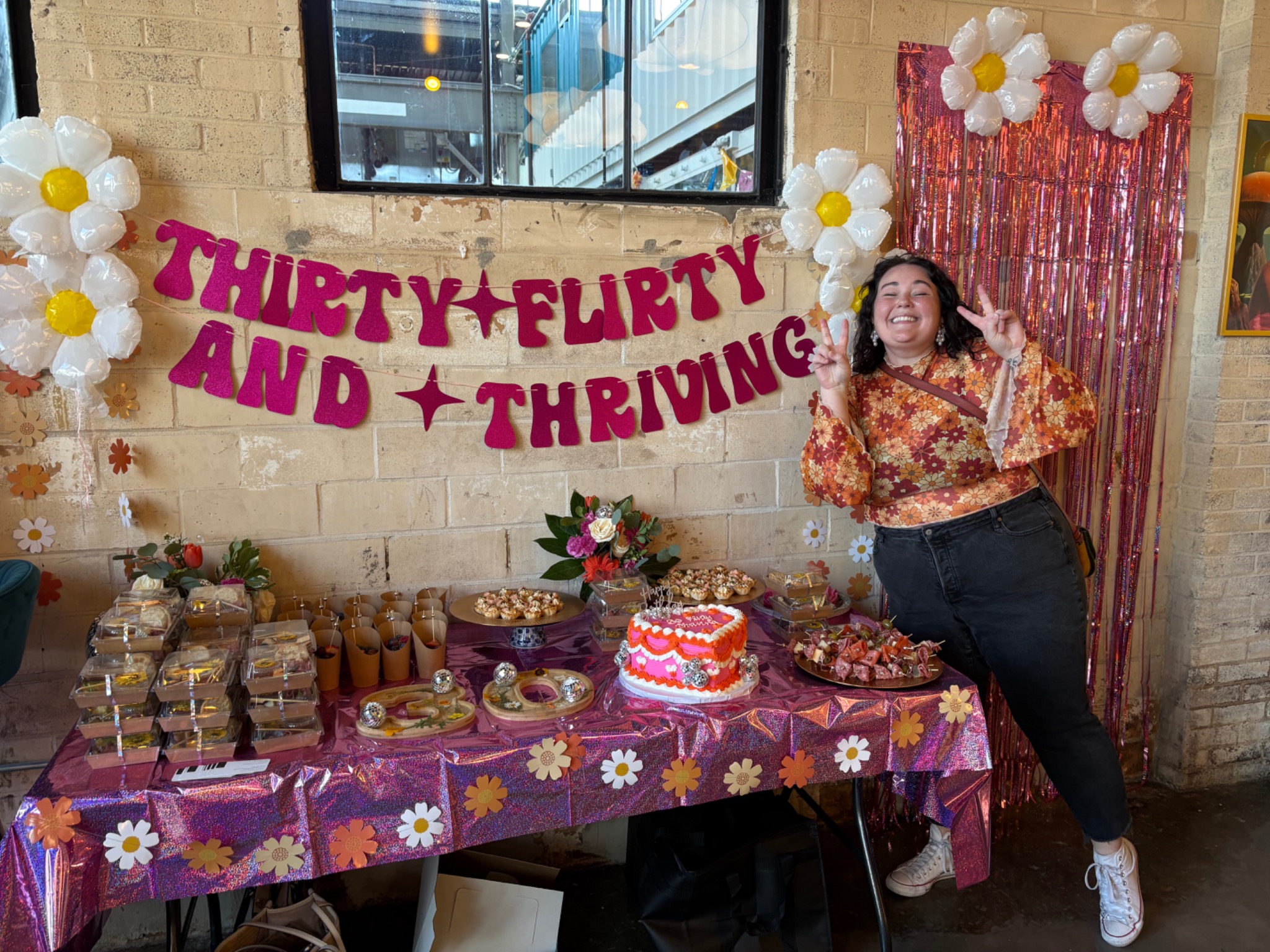 Birthday guest celebrating beside a colorful custom dessert table