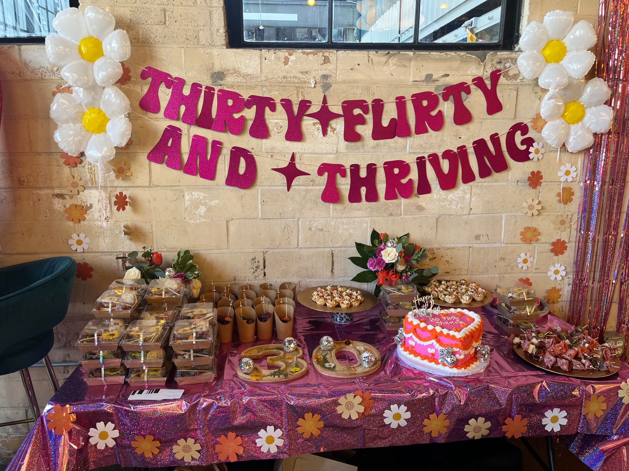 Retro floral thirtieth birthday dessert table with balloon daisies and custom signage